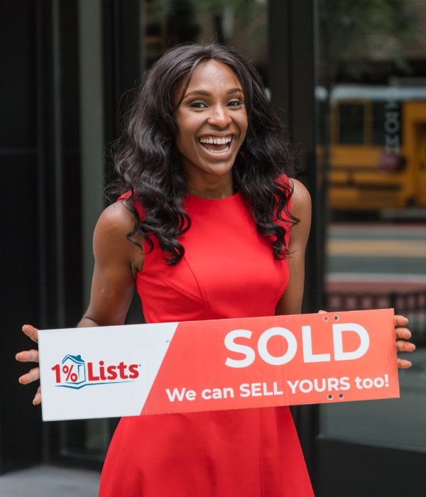 Client holding a 1 Percent Lists sold sign